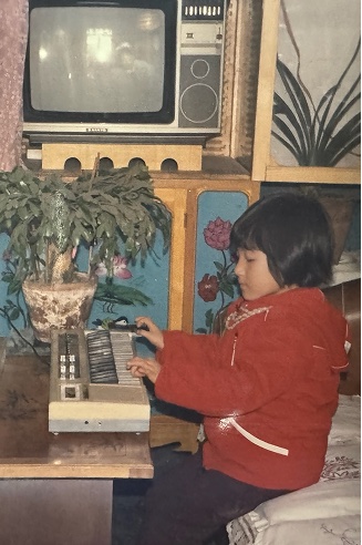 Ke as a child at a keyboard